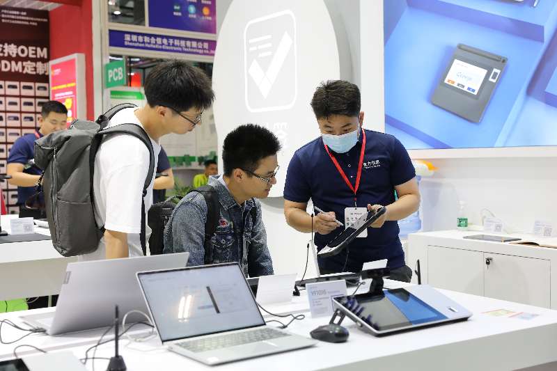 Haveways staff demonstrating digital signature pad for trade show visitors